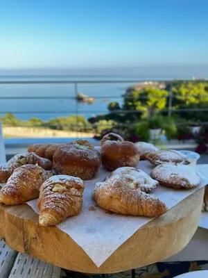 a tray of pastries and donuts on a table at Zabbàra B&B in Terrasini