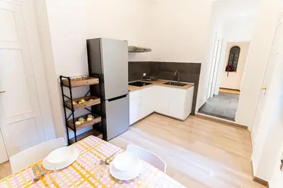 a kitchen with a table and a refrigerator at Central Coa Apartment in Palermo