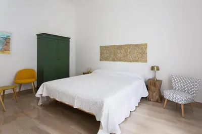 a bedroom with a bed and a green cabinet and chairs at Central Coa Apartment in Palermo