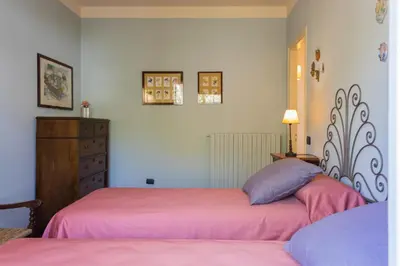 a bedroom with two beds with pink sheets and a dresser at Villa Gabriella - Mondello in Mondello