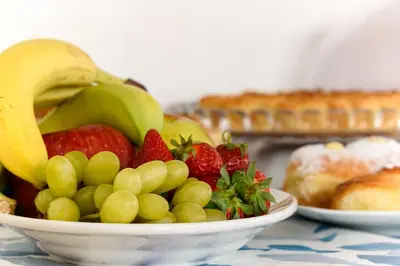 a bowl of fruit with strawberries and bananas on a table at La Meridiana Hotel in San Vito lo Capo