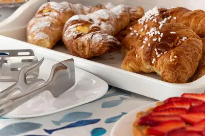 a tray of pastries and strawberries on a table at La Meridiana Hotel in San Vito lo Capo