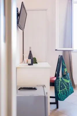 a white table with a bottle of wine and a bag at Casa da Silvia in Palermo