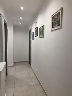 a hallway with white walls and pictures on the wall at STABILE139 in Palermo