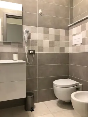 a bathroom with a toilet and a phone on the wall at STABILE139 in Palermo