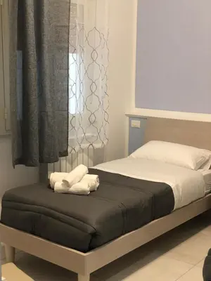 a bedroom with a bed with two towels on it at STABILE139 in Palermo
