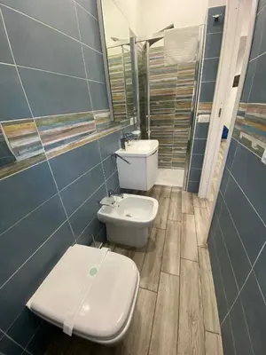 a bathroom with a toilet and a sink at IN CENTRO ROOMS Vicino Cefalù SELF-CHEK-IN in Campofelice di Roccella