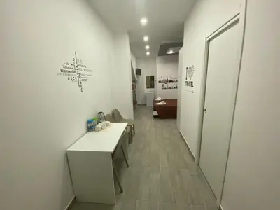 a room with white walls and a hallway with a table at IN CENTRO ROOMS Vicino Cefalù SELF-CHEK-IN in Campofelice di Roccella
