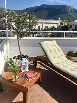 a balcony with two couches and a table and a tree at Alto Giardino Rooms in Terrasini