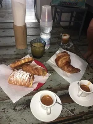 a table with croissants and cups of coffee and croissants at Alto Giardino Rooms in Terrasini