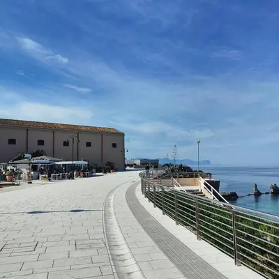 a walkway next to the water near a building at Alto Giardino Rooms in Terrasini