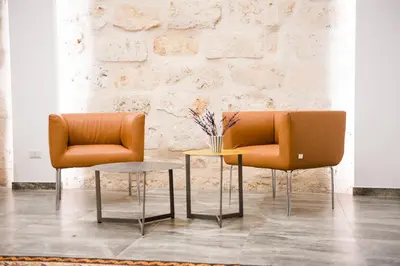 two orange chairs and a table in front of a brick wall at CIELO D' ALCAMO Palazzo Adamo in Alcamo