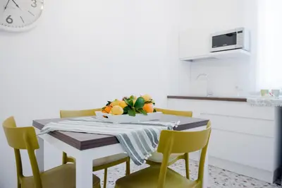 a dining room table with chairs and a bowl of fruit at CIELO D' ALCAMO Palazzo Adamo in Alcamo
