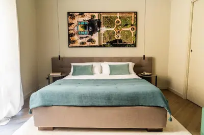 a bedroom with a bed and a painting on the wall at InCanto in Palermo