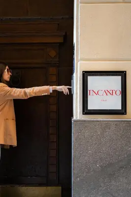 a woman pointing at a sign on a building at InCanto in Palermo