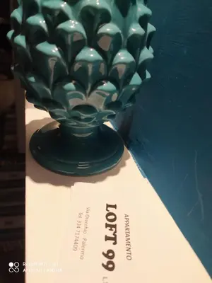 a green glass vase sitting on top of a table at LOFT 99 in Palermo