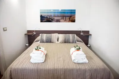 a bedroom with a bed with towels on it at Casa Vela Bianca Mondello Addaura in Palermo