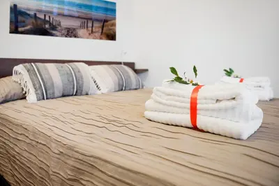a pile of towels sitting on top of a bed at Casa Vela Bianca Mondello Addaura in Palermo