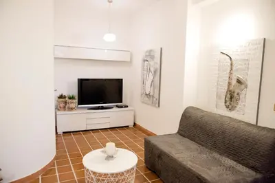 a living room with a couch and a tv at Casa Vela Bianca Mondello Addaura in Palermo