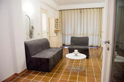 a living room with two chairs and a table at Casa Vela Bianca Mondello Addaura in Palermo