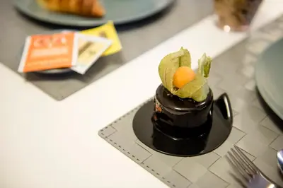 a chocolate cake with a fruit on top on a table at Casa Vela Bianca Mondello Addaura in Palermo