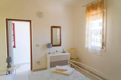 a white bathroom with a mirror and a sink at Villa Claudia e Simone in Carini