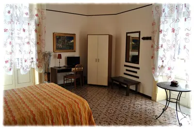 a bedroom with a bed and a desk and a mirror at Bed and Breakfast D'Angelo in Palermo