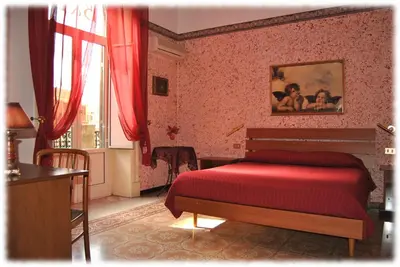 a bedroom with a red bed and a window at Bed and Breakfast D'Angelo in Palermo