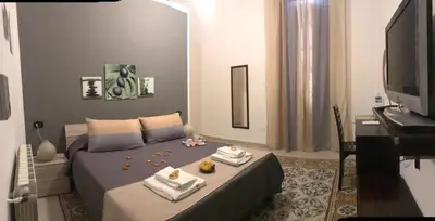 a bedroom with a bed with towels and a television at BONORUM in Palermo