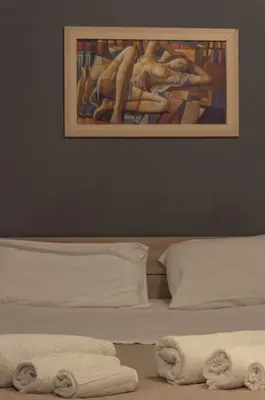 a bedroom with a painting above a bed with towels at BONORUM in Palermo