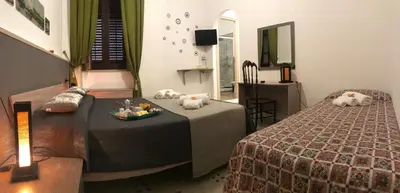 a hotel room with two beds and a table and chair at BONORUM in Palermo