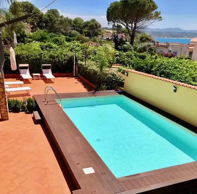 a swimming pool on a patio with chairs around it at La Caletta Casa Vacanze, PRIVATE POOL in Terrasini