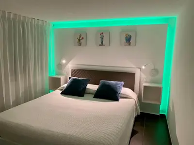 a bedroom with a bed with green lights on it at La Caletta Casa Vacanze, PRIVATE POOL in Terrasini