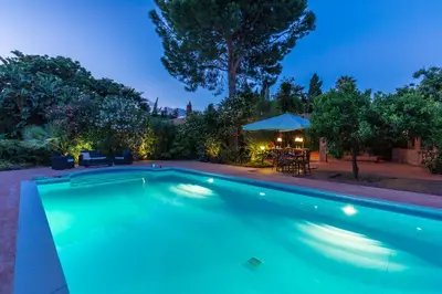 a swimming pool in a backyard at night at Il Giardino di Michela by DomuSicily in Mondello