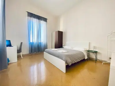a white bedroom with a bed and a table at Mamamia #Politeama in Palermo