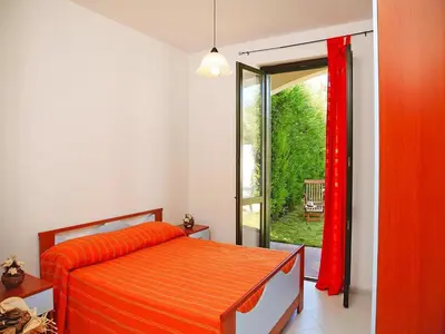 a bedroom with a bed and a sliding glass door at Residence in Sicily near Himera & Madonie Park in Buonfornello