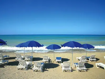 a group of chairs and umbrellas on a beach at Residence in Sicily near Himera & Madonie Park in Buonfornello