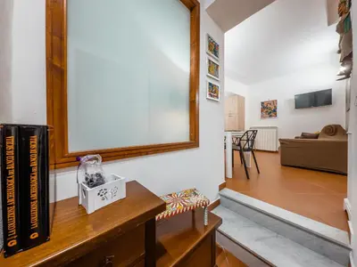 a living room with a tv and a table with books at Casa Ruggiero in Palermo