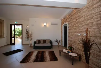 a living room with a couch and a brick wall at Trigrana Vacanze Hotel in Castelluzzo