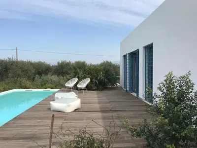 two chairs sitting on the balcony of a white building at casa zabbara in Balestrate