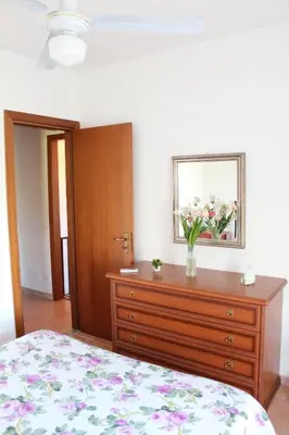 a bedroom with a dresser with a vase of flowers on it at Villetta con giardino Mandarino Macari in Macari