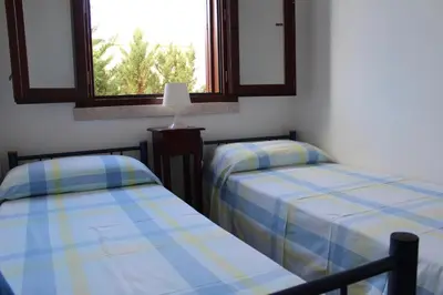 two beds in a room with a window at Villetta con giardino Mandarino Macari in Macari