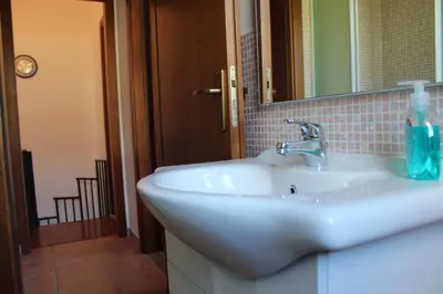 a bathroom with a sink and a mirror at Villetta con giardino Mandarino Macari in Macari