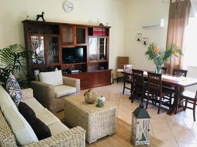 a living room with a table and a dining room at Villa Araucaria in Partinico