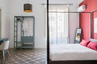 a bedroom with a bed and a pink wall at B&B Palazzo Corselli in Bagheria