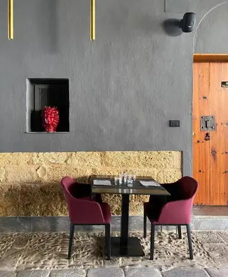 a table with two chairs and a red vase at B&B Palazzo Corselli in Bagheria