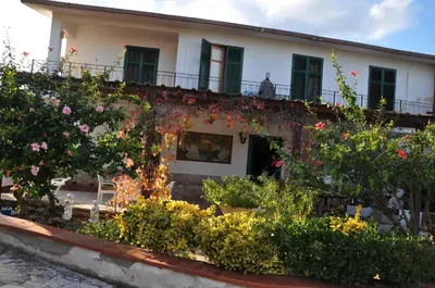 a large white house with a brick patio at Corso's old nest a mille metri dalla spiaggia guida loca in Castellammare del Golfo