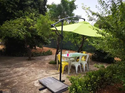 a table and chairs under a yellow umbrella at Villa Serrano in Palermo