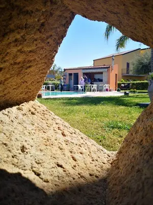 a view through a hole in a wall of a yard at Beb oasi marina in Campofelice di Roccella
