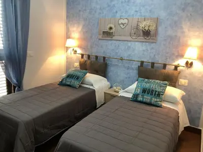 a hotel room with two beds and a couch at Beb oasi marina in Campofelice di Roccella
